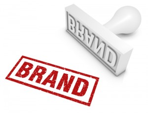 Image of a rubber stamp stamping the word brand. 