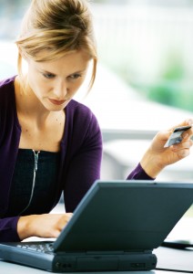 Woman Using Laptop Computer And Holding Credit Card