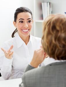 Photo of a woman talking excitedly to another woman