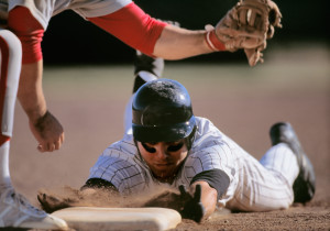 Baseball player sliding into base with baseman catching ball