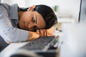 Indian businesswoman sleeping on desk in office