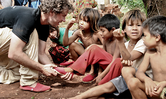 Blake Mycoskie, founder of TOMS delivering shoes. Photo courtesy of Tom's Shoes