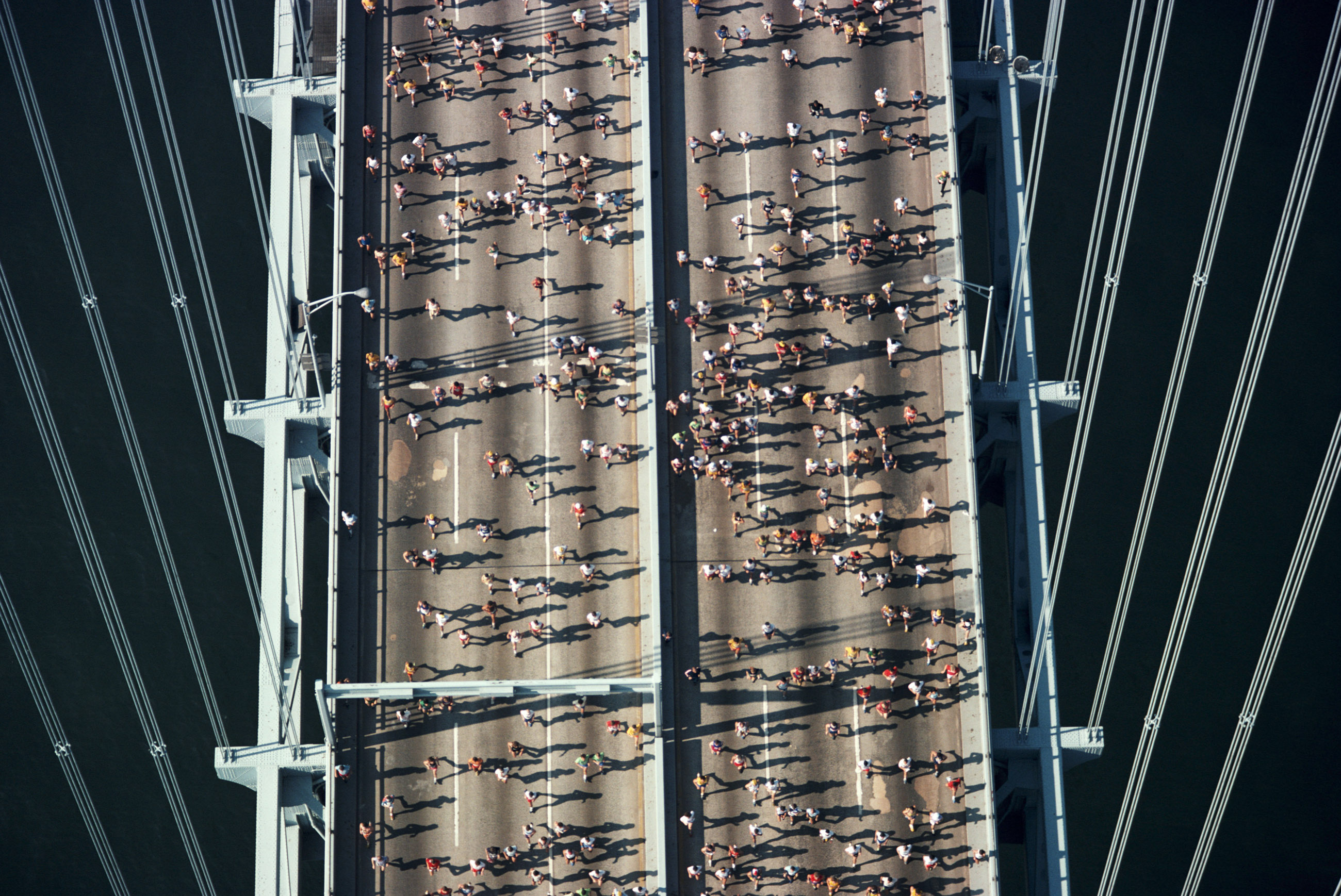 Marathoners running across bridge, elevated view