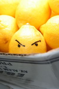 lemon with angry face in a bucket of lemons
