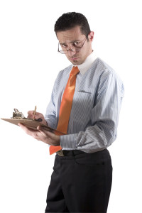businessman looking over his glasses with clipboard on hand - fr
