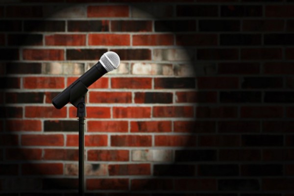 Artistic image of microphone against a rustic brick wall with sp