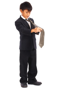 Young Boy In Suit Doing His Tie