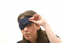 Woman wearing a blindfold isolated over white