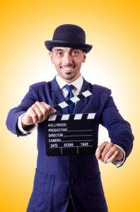 Man with movie clapper isolated on white
