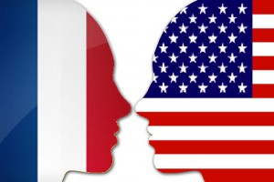 two profiles face each other one with a French flag overlaid and the other with an American flag