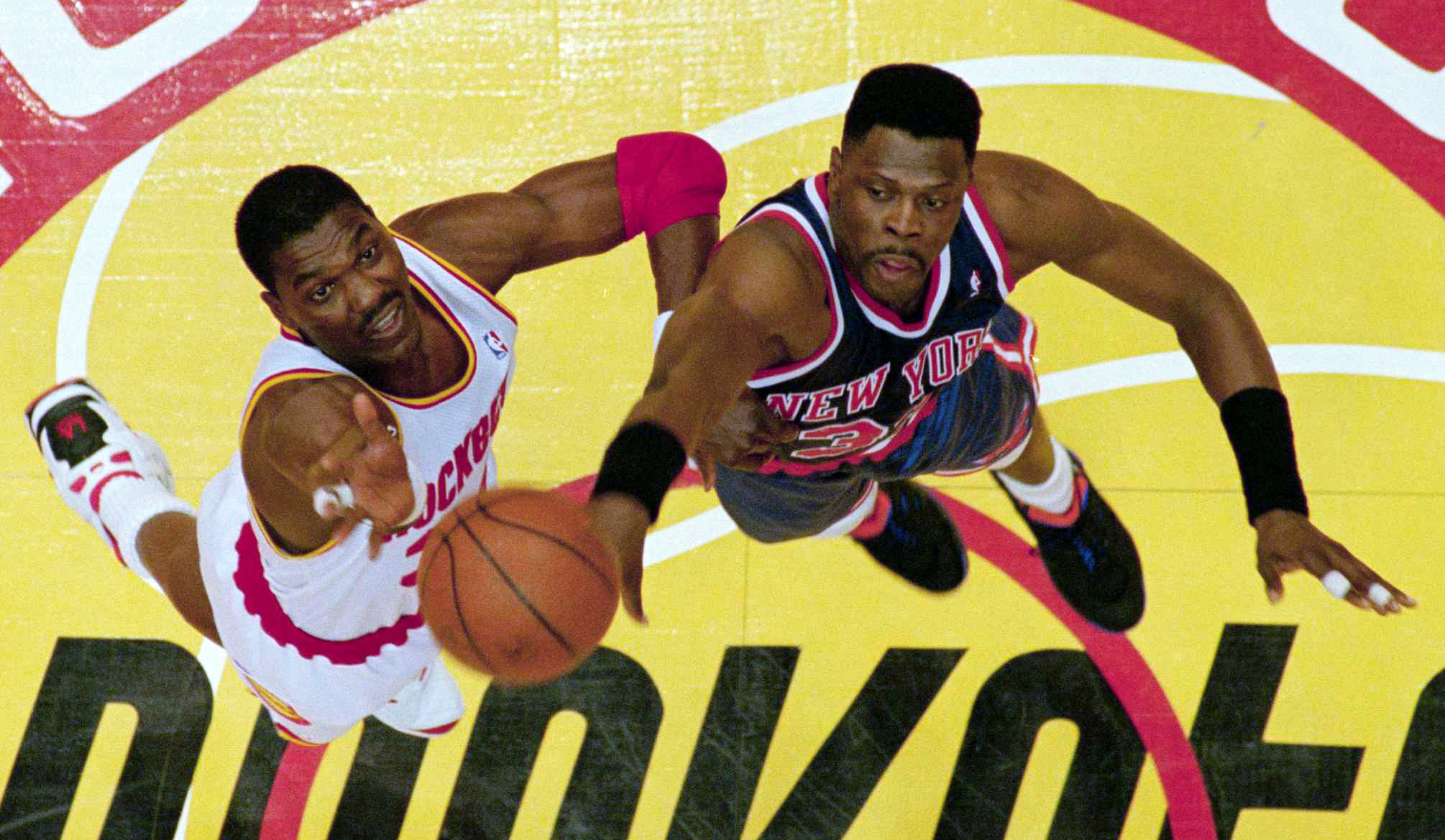 Houston Rockets center Hakeem Olajuwon and New York Knicks center Patrick Ewing face off in a jump-ball situation.