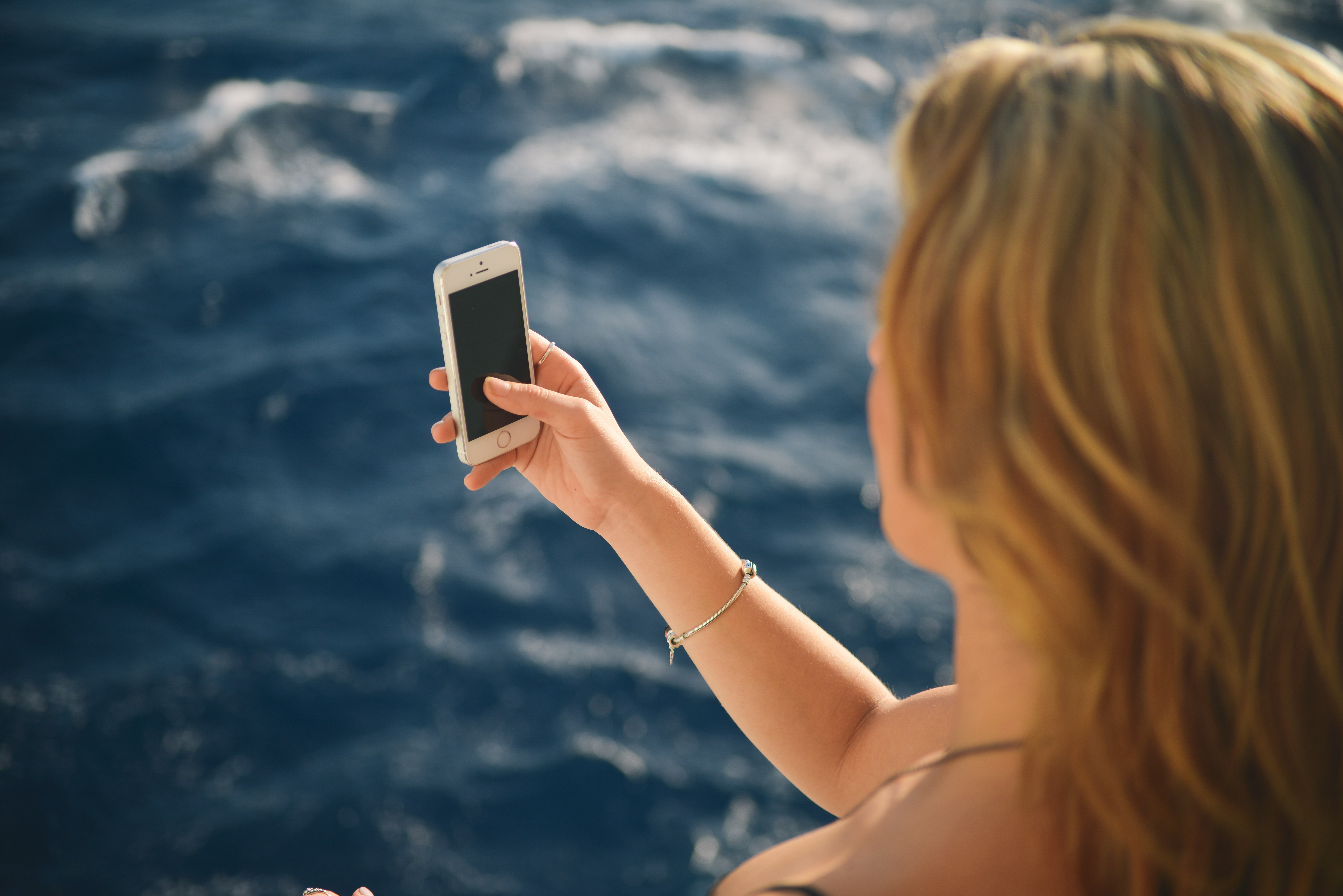 Woman Using Smartphone  With Beautiful Blue Ocean