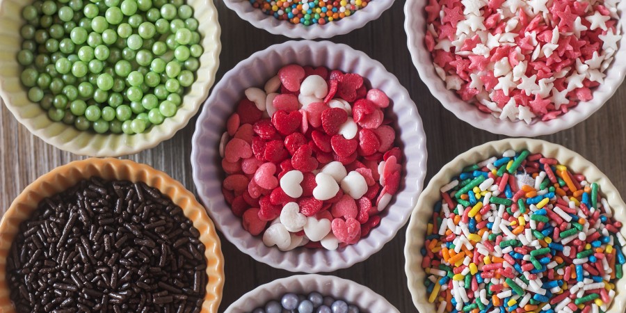 Colorful cupcake spinkles in bowls over a wooden table