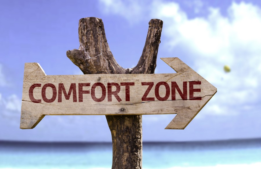 Comfort Zone wooden sign with a beach on background