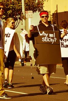 picture of a guy with a sign over his chest that reads "why am I sticky".