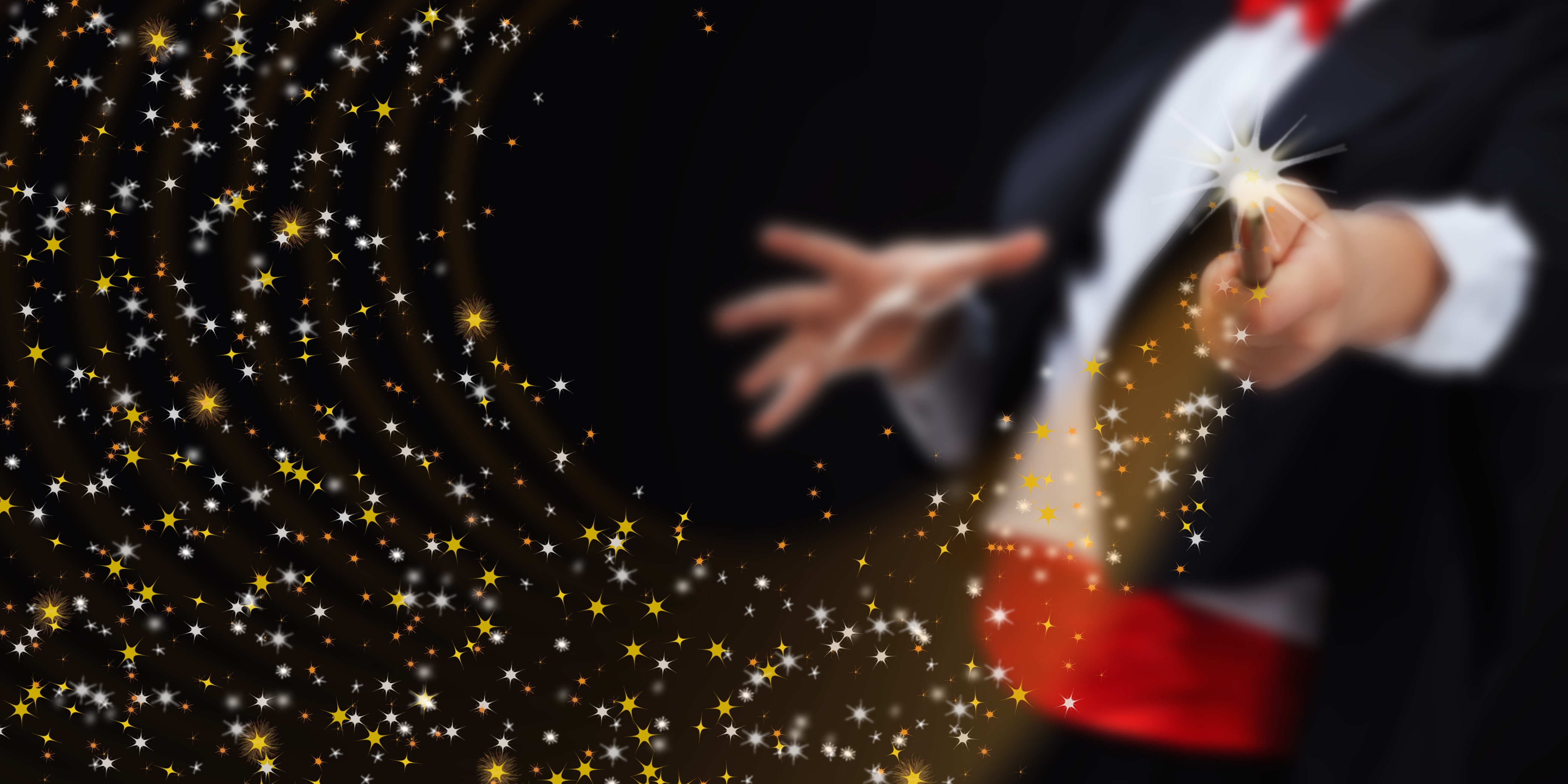 Magician hands with magic wand conjuring sparkling stars stream - copy space