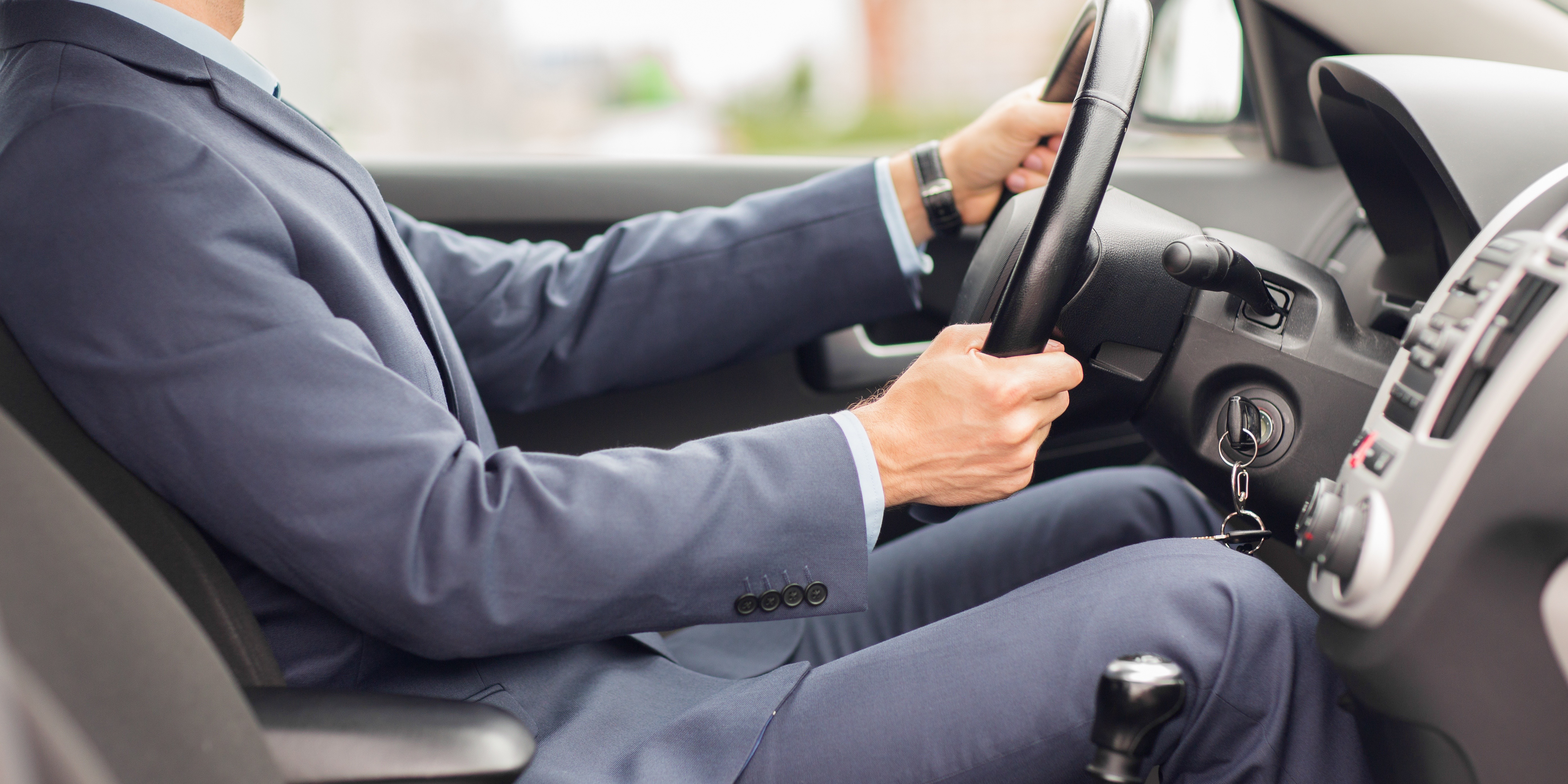 transport, business trip, destination and people concept - close up of young man in suit driving car