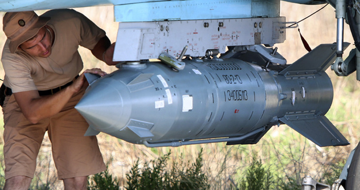 In this photo taken on Saturday, Oct. 3, 2015, Russian military support crew attach a satellite guided bomb to SU-34 jet fighter at Hmeimim airbase in Syria. Russia has insisted that the airstrikes that began Wednesday are targeting the Islamic State group and al-Qaida