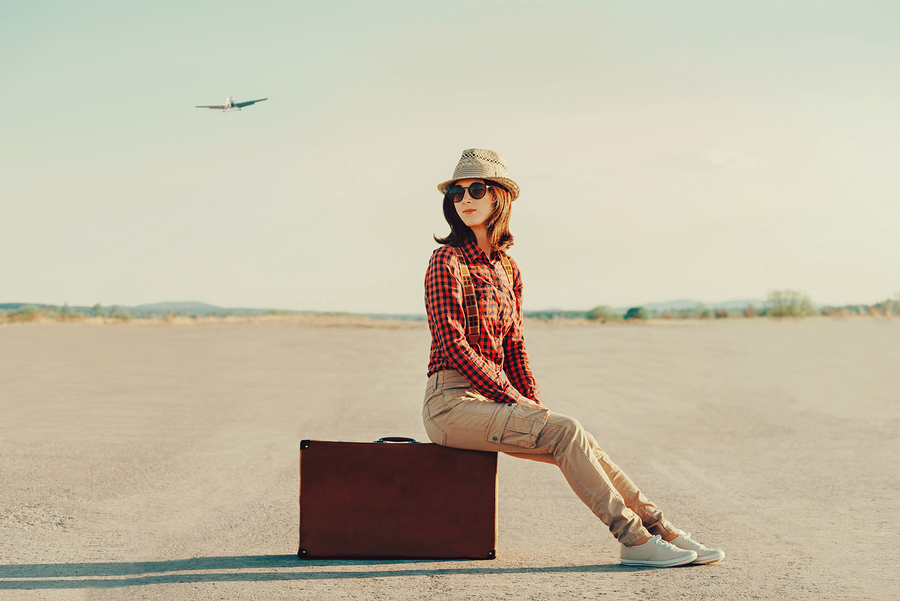 Traveler Woman Sitting On Suitcase On Road