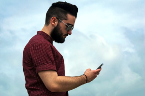 Man_Using_Smartphone_Sky_Background_-_Mobile_Strategies