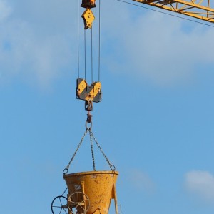 Heavy load is transported, high above workers