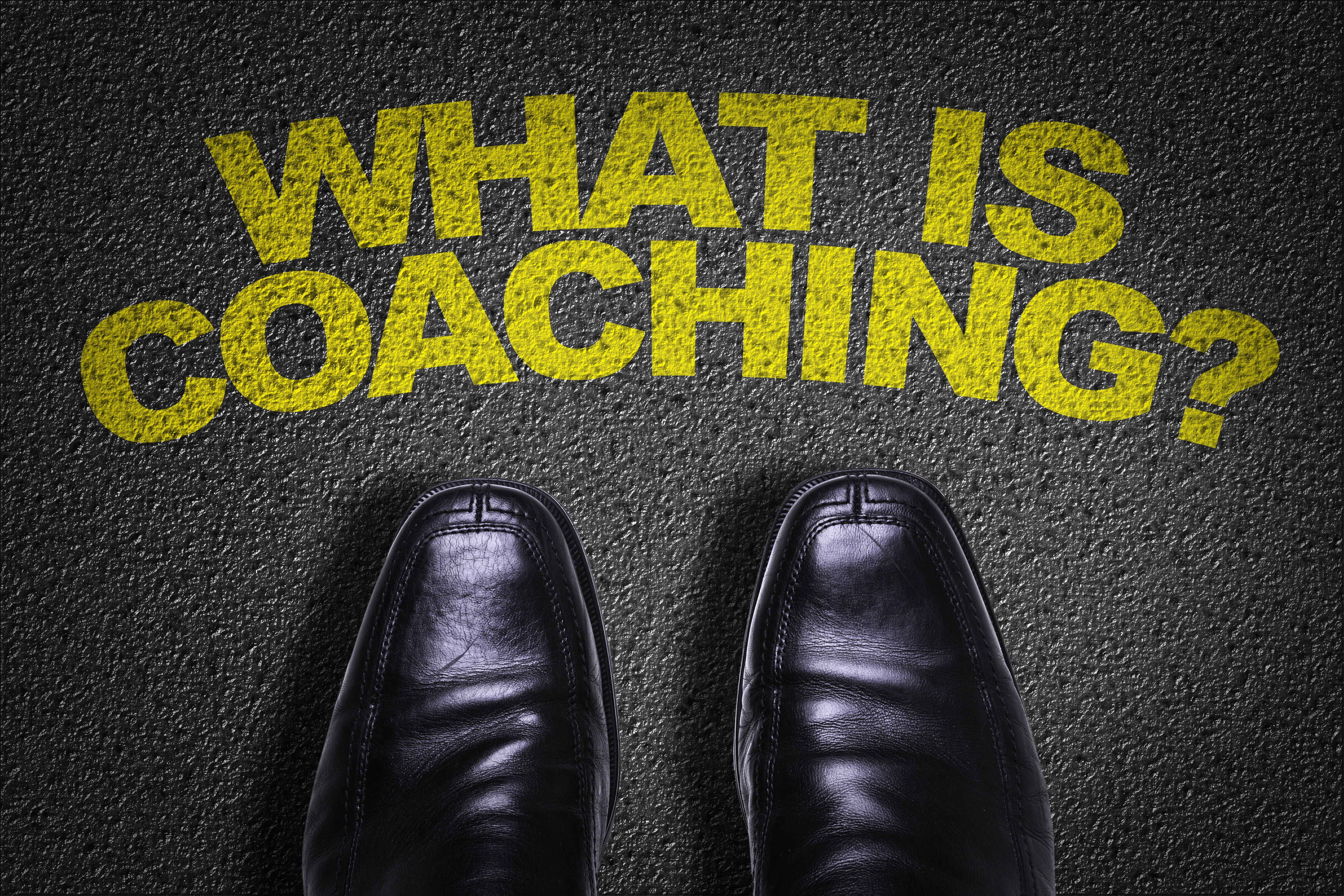 Top View of Business Shoes on the floor with the text: What Is Coaching?
