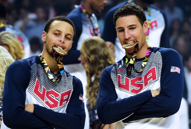 Stephen Curry (left) and Klay Thompson bite their gold medals after winning the 2014 FIBA Basketball World Cup.