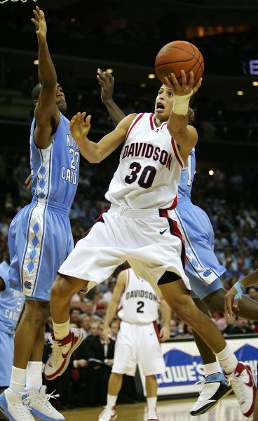 Stephen Curry of the Davidson Wildcats drives to the basket against Wayne Ellington of the North Carolina Tar Heels.
