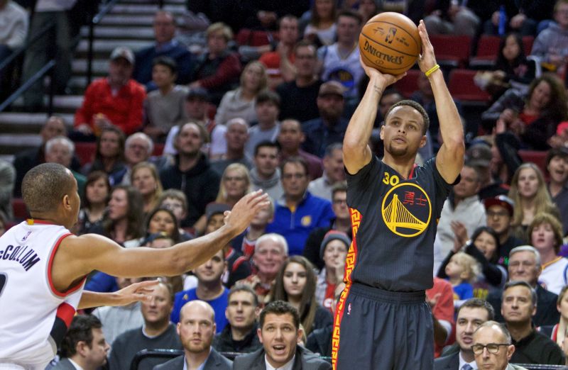 Stephen Curry of the Golden State Warriors shoots over C.J. McCollum of the Portland Trail Blazers