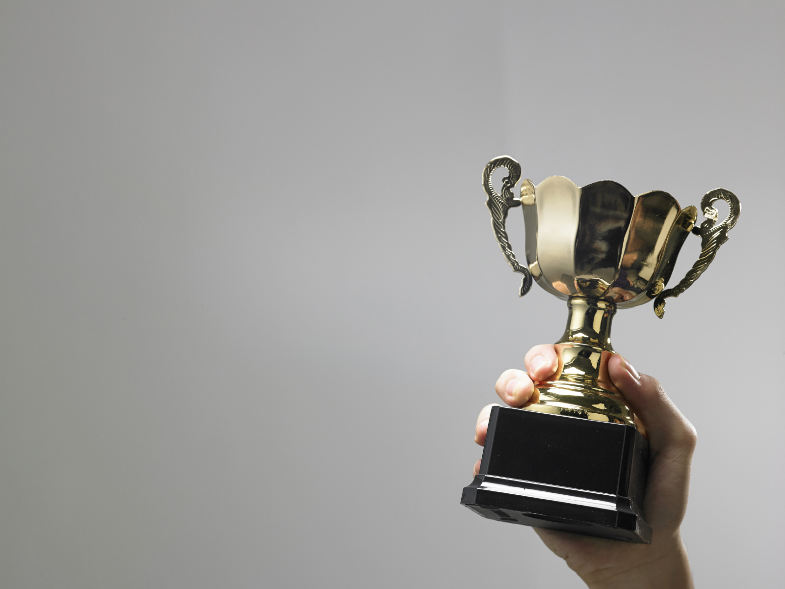 Man holding a champion golden trophy