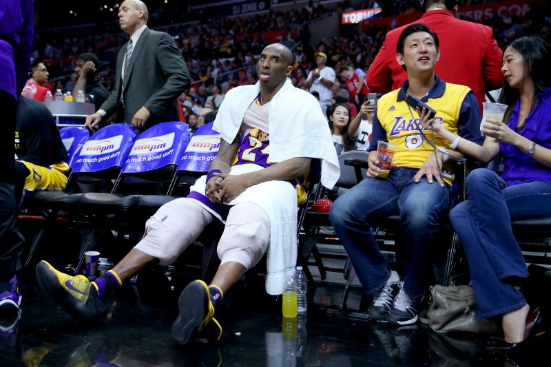 Los Angeles Lakers guard Kobe Bryant sits on the bench covered in ice.