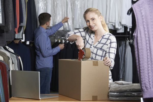 Couple Running Online Clothing Store Packing Goods For Dispatch