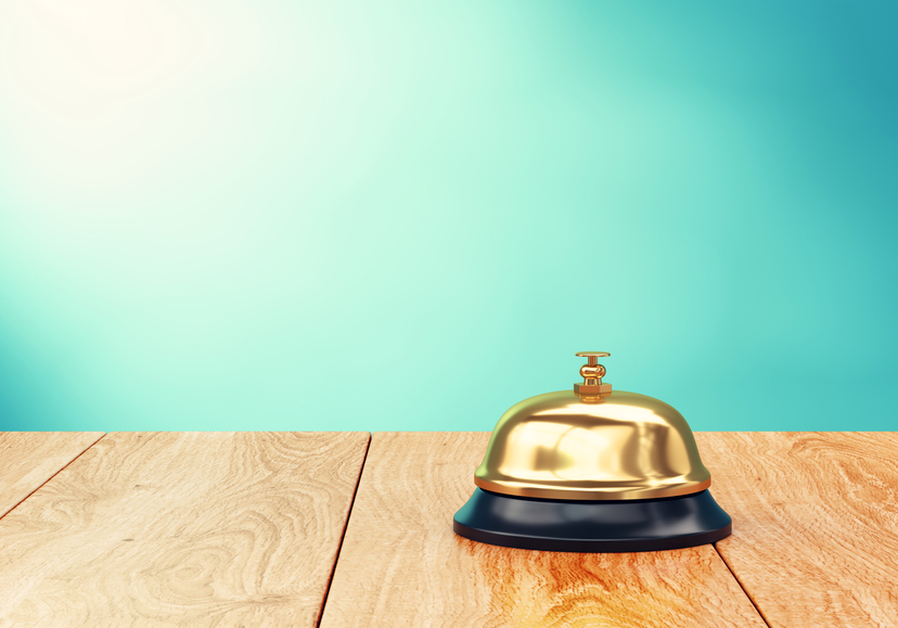Brass hotel reception bell on wood desk. 3D illustration