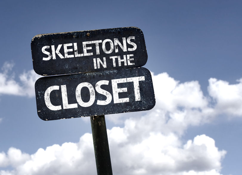 skeletons in the closet sign with clouds and sky background