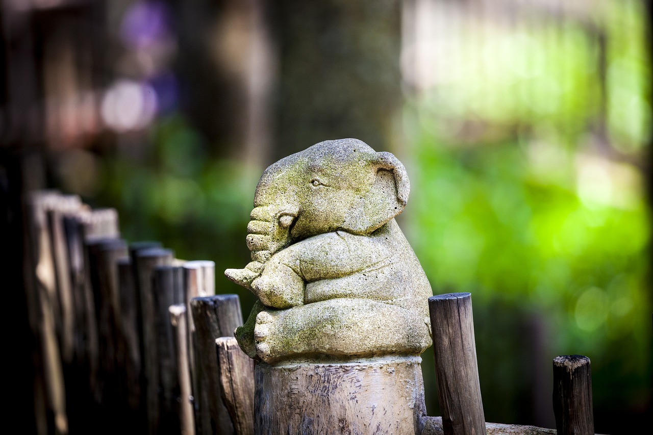 An Elephant Statue Sits on a Fence Post