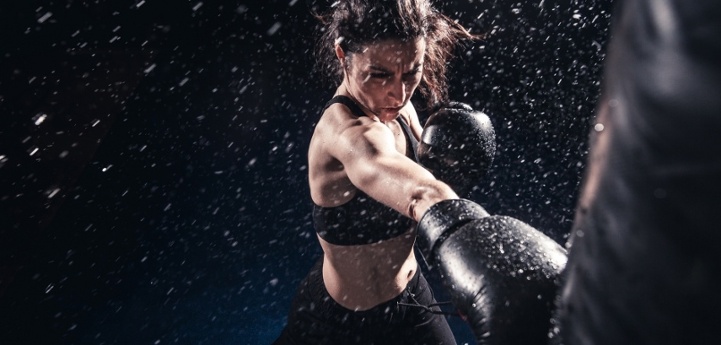 woman fiercely hitting a punching bag