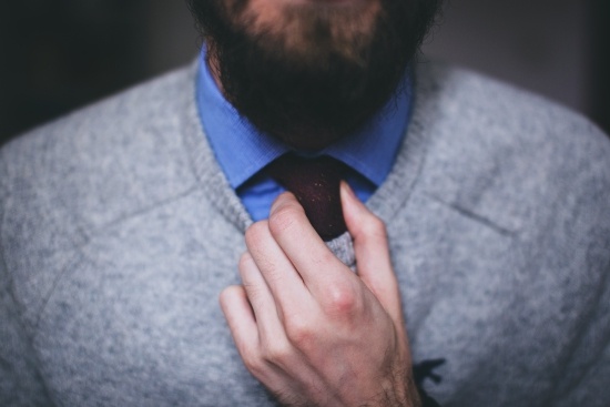 bearded man adjusting his tie hoping to be hired internally