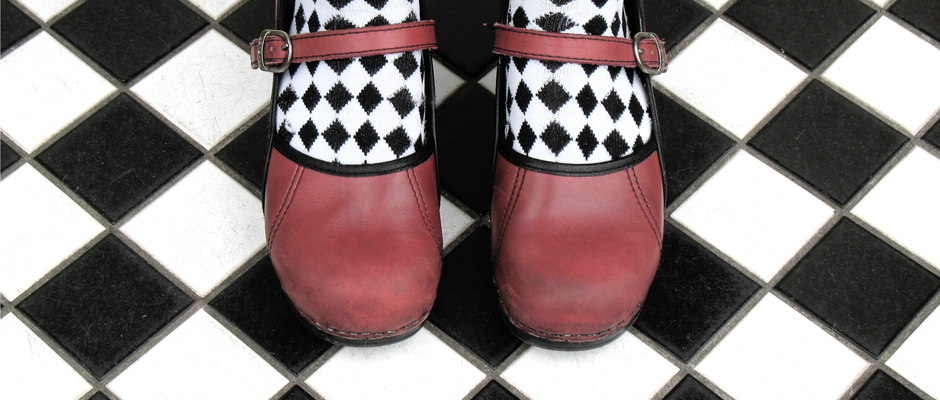 red mary jane shoes on black and white checkered floor
