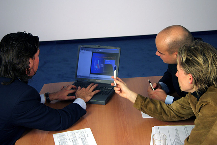 Three people viewing a computer