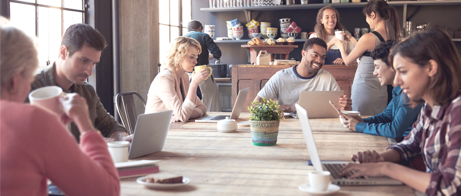a group of people in a coffee shop on computers