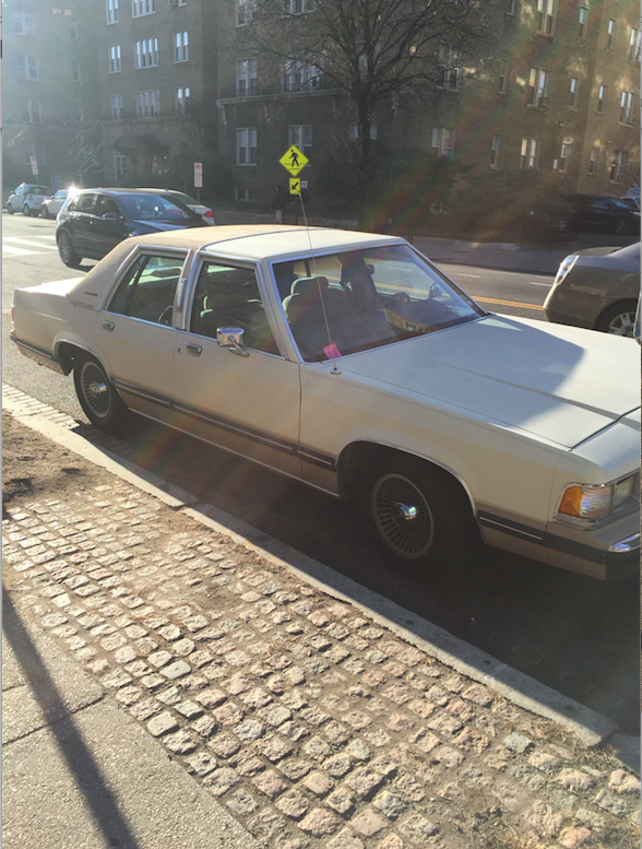 A white sedan parked along the curb