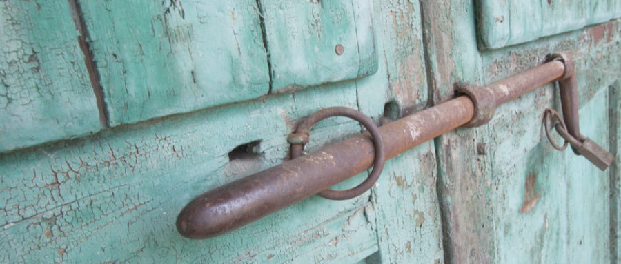 a metal latch and lock on a aqua painted door