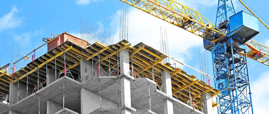 Crane and building under construction against blue sky
