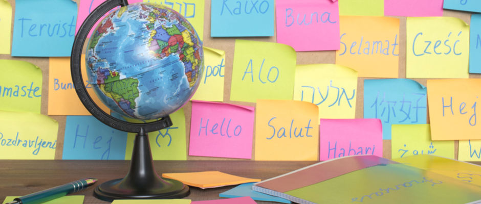 a globe in front of a wall with post its with foreign words written on them