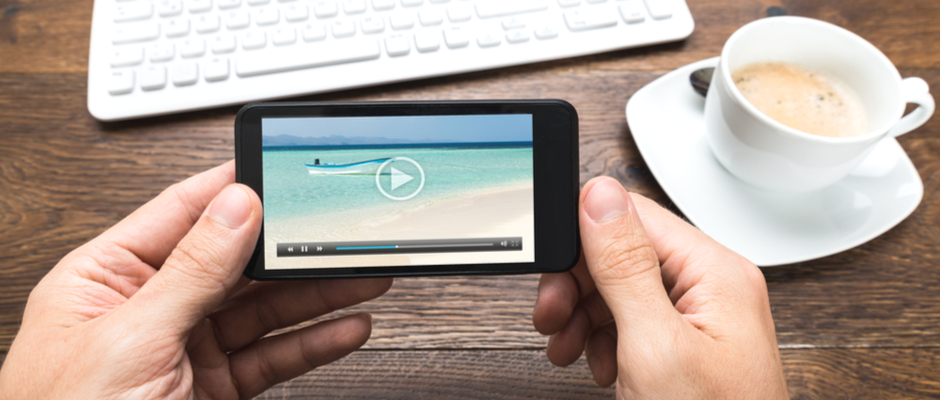 hands holding a mobile phone watching a video