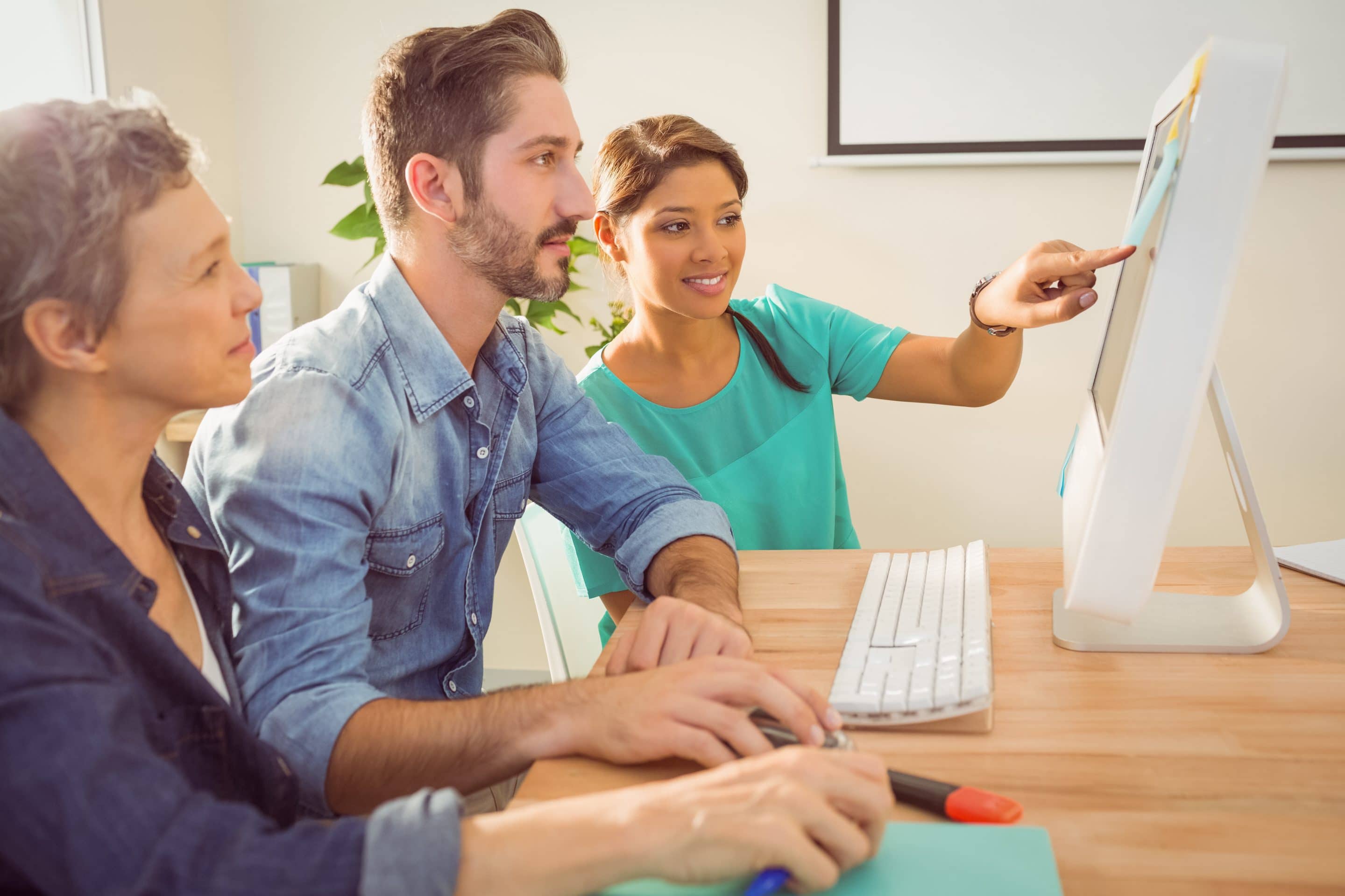 Group of young colleagues using laptop at office