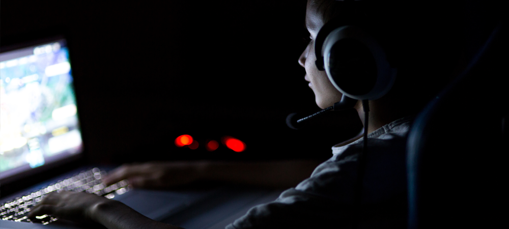 Young boy playing video games in the dark