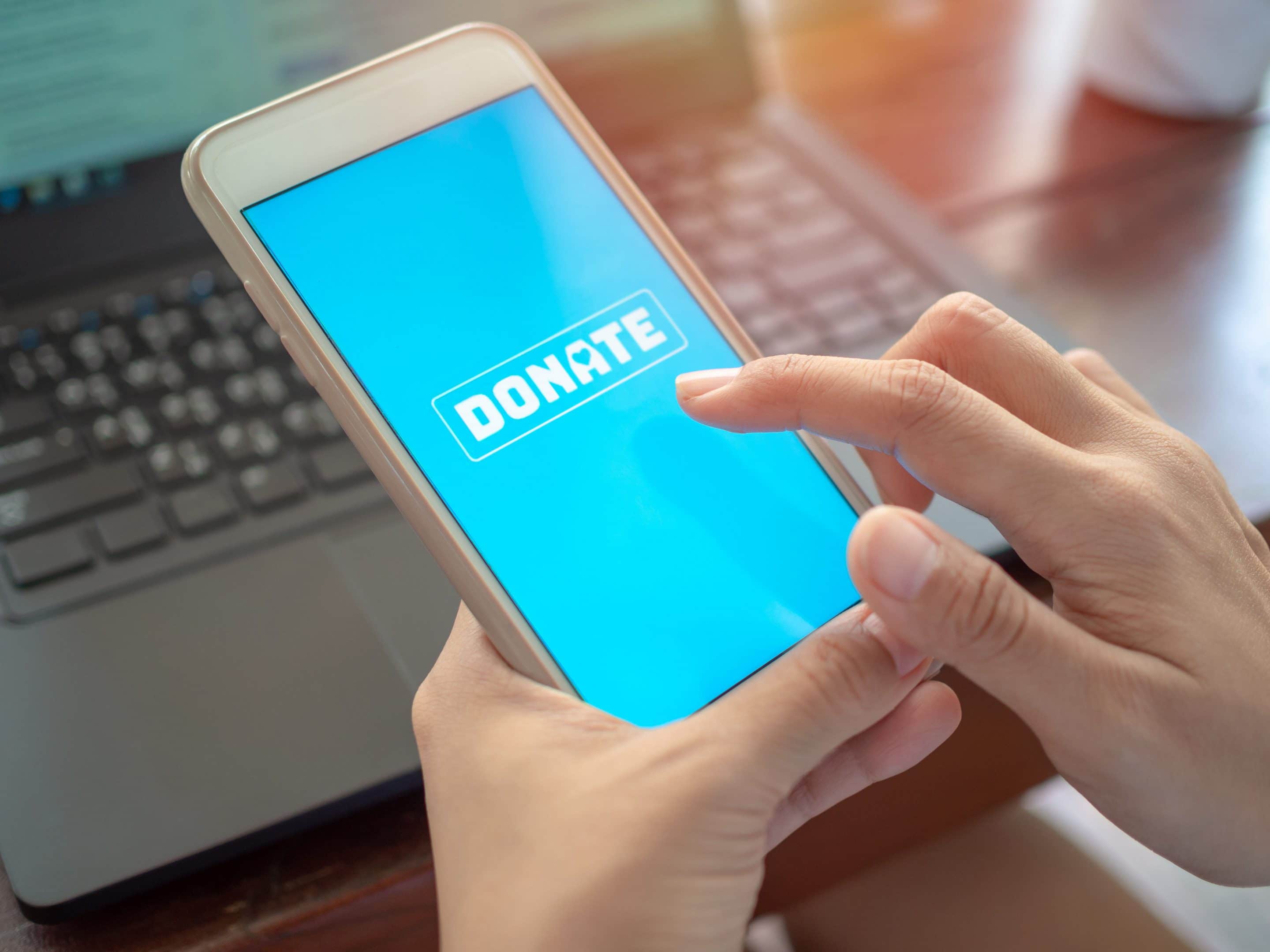 A cell phone with a donate button for a nonprofit.
