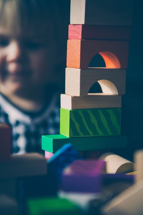 Child building a tower with wooden blocks
