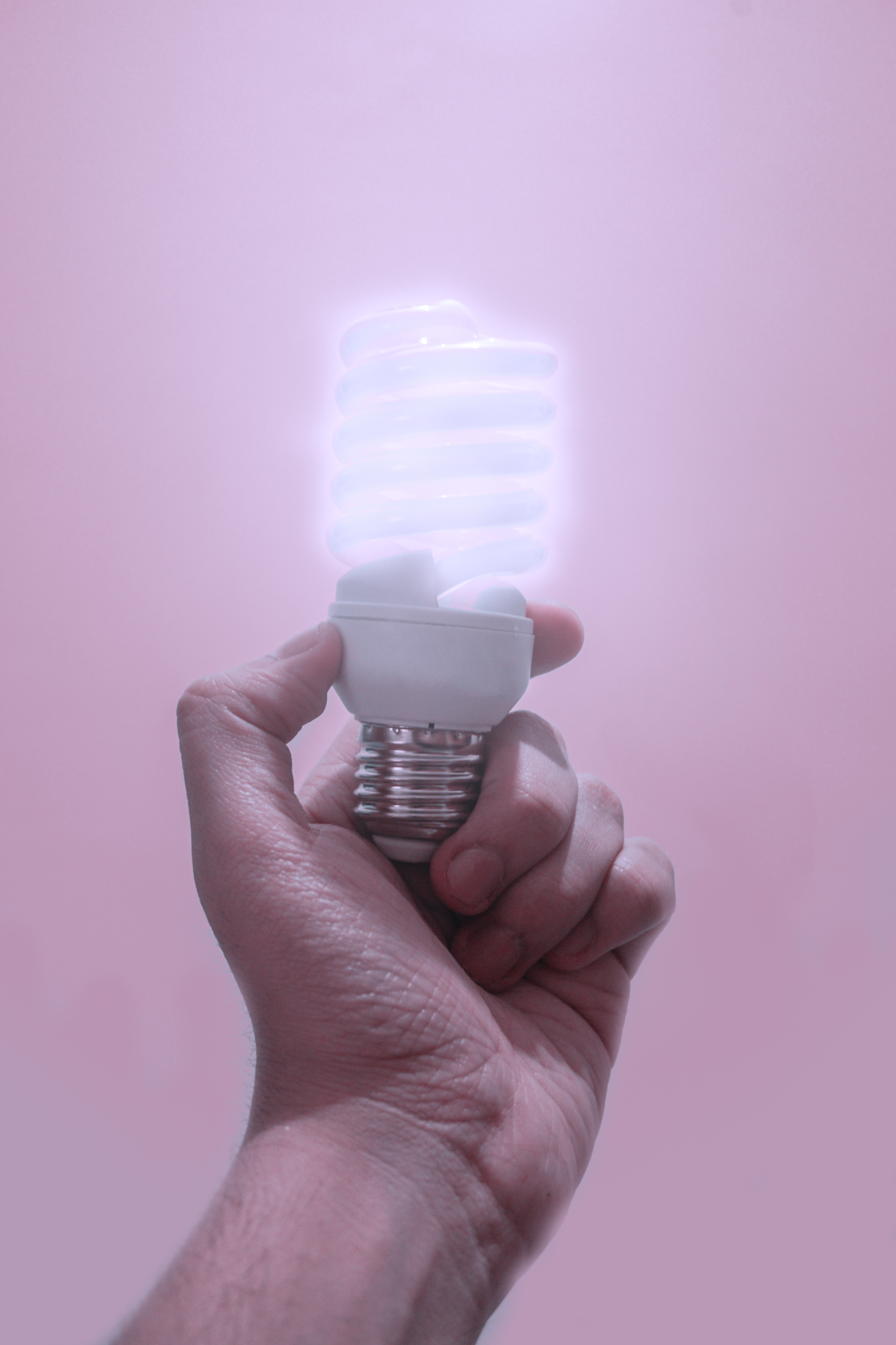 person holding a turned on light bulb